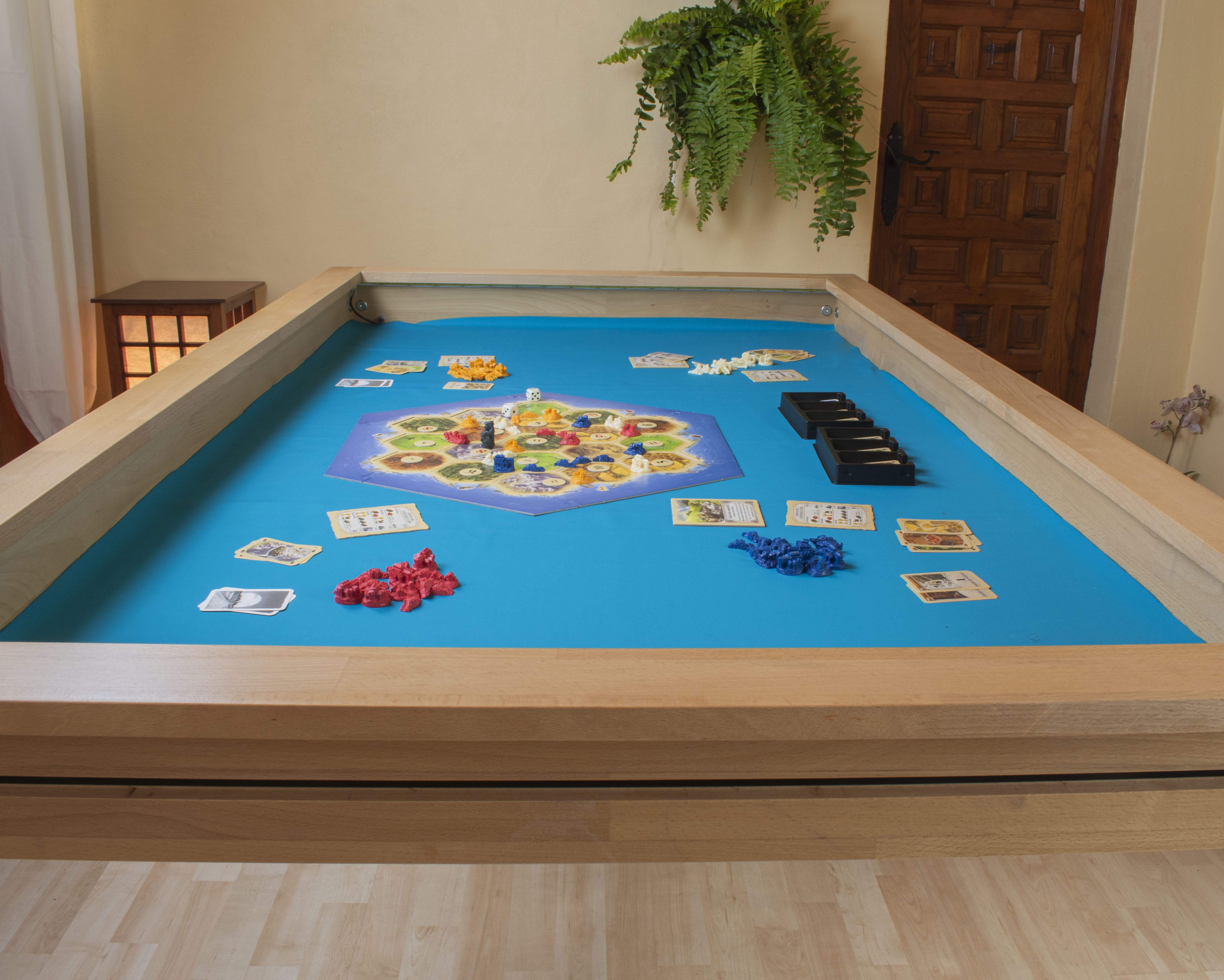 Mesa amplia para juegos de mesa mostrando partida de Catán